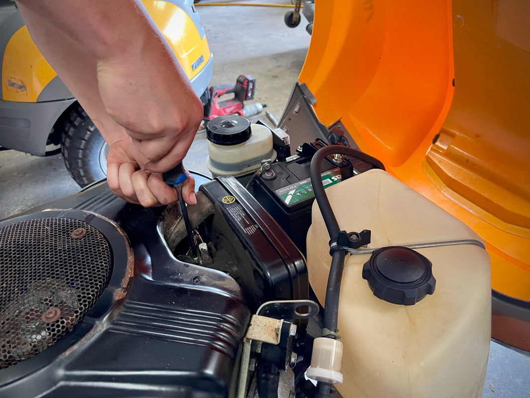 Technician servicing ride on lawnmower